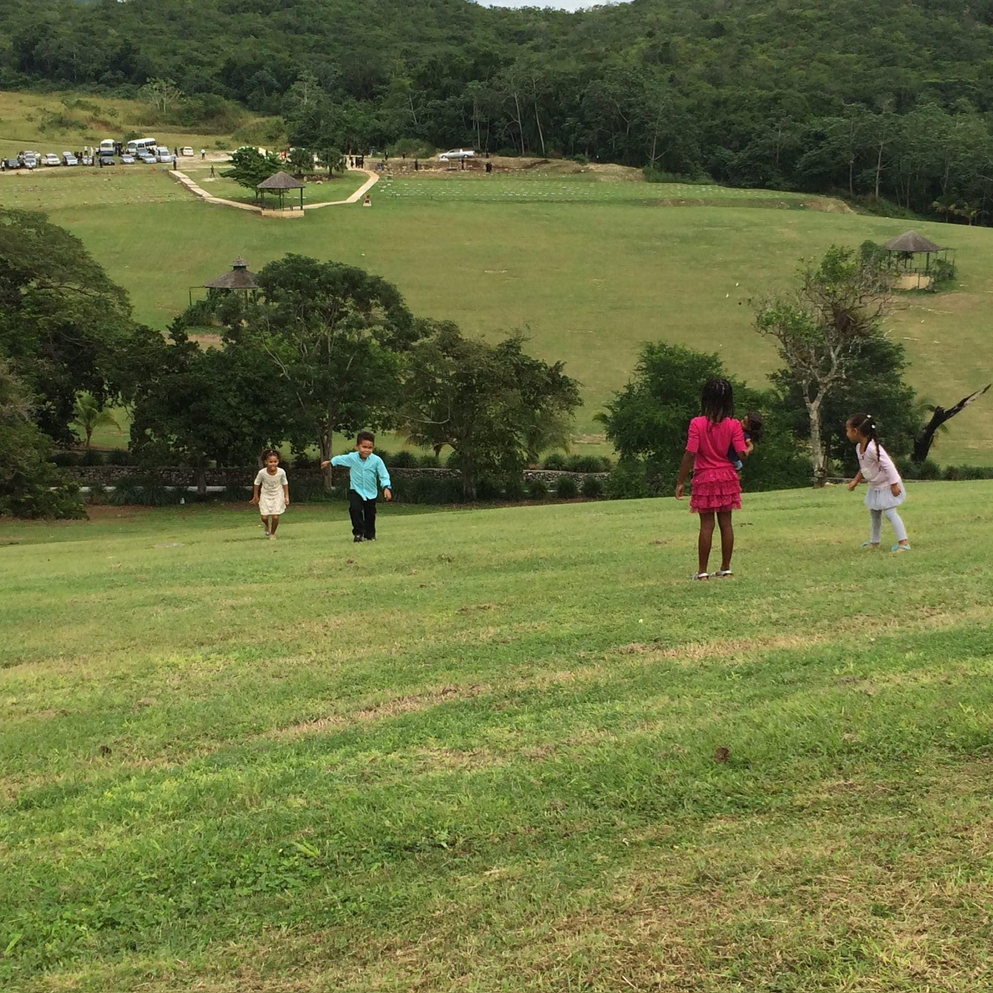 Children running down the grassy hillside